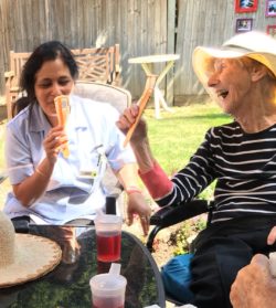Care home resident and carer enjoy ice lollies
